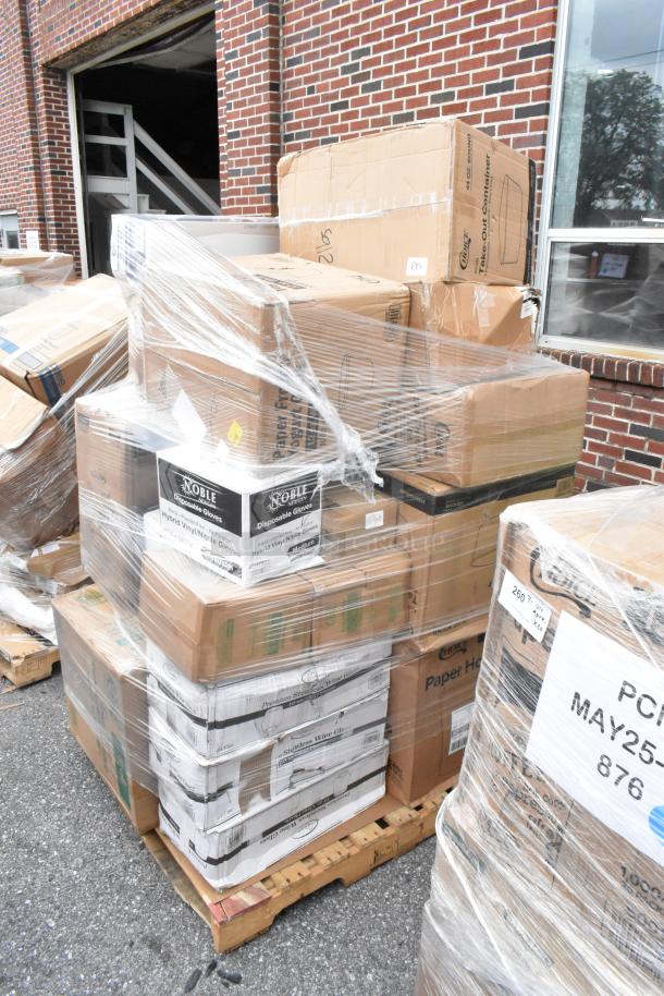 Pallet with stacked cardboard boxes and Noble Disposable Gloves labels, wrapped in plastic, set outside a brick building.