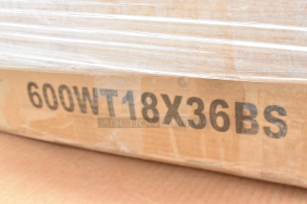 Cardboard box with black marking "600WT18X36BS," partially wrapped in clear plastic. Condition appears new.
