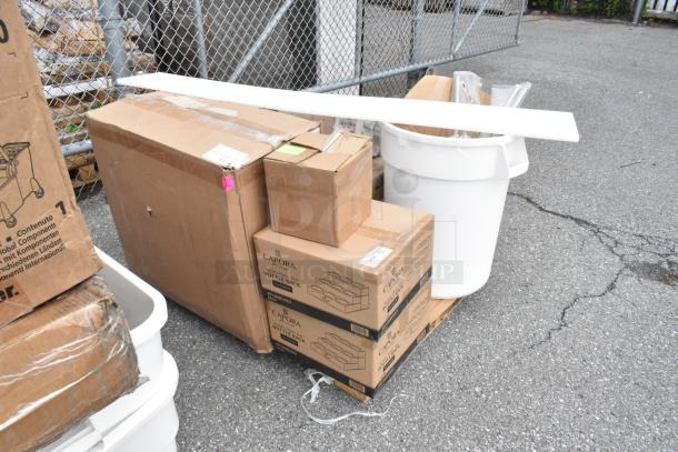 Boxes of Capora wine bottle racks, sealed, on a pallet with additional packages and a white plastic bin.