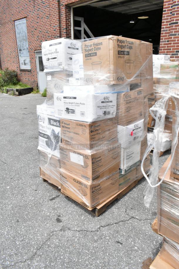Pallet of boxed disposable supplies, including paper yogurt cups and cutlery packs, wrapped in plastic. Visible brand: Clover.