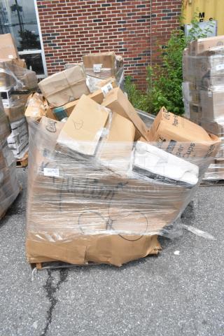 Pallet of assorted cardboard boxes wrapped in plastic, mixed condition, includes labeled boxes, outdoor setting.