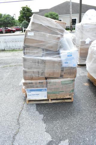Pallet of assorted packaged goods wrapped in plastic, including Jumbo Toilet Paper and Dispenser Napkins.