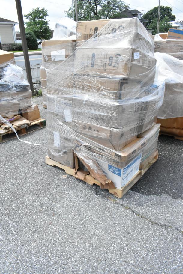 Pallet of assorted cardboard boxes wrapped in plastic, some labeled "White Paper," stacked on wooden base, outdoor setting.