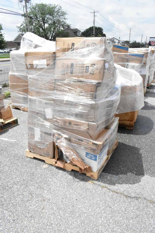 Pallet of assorted boxed items wrapped in plastic, visible labels include “White 7z0” and “Box 87,” stored on asphalt.