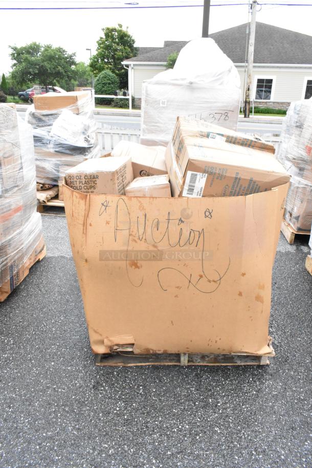 Cardboard bin labeled "Auction" containing assorted boxes, visibly weathered, on a pallet, outdoors.