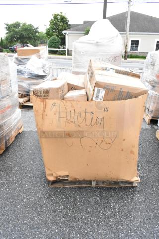 Cardboard bin labeled "Auction" containing assorted boxes, visibly weathered, on a pallet, outdoors.