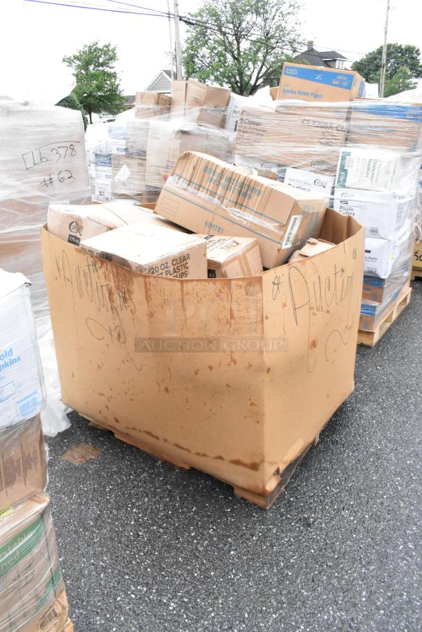 Large cardboard box labeled "Auction" on pallet, filled with assorted wrapped cardboard boxes. Visible markings indicate lot numbers.