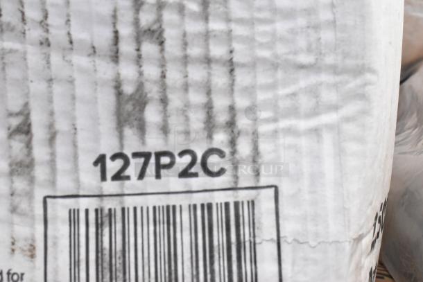 Close-up of a shipping box with the code "127P2C" and a barcode, showing wear and slight discoloration.