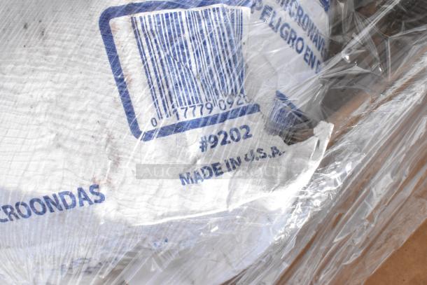 Plastic-wrapped item with visible barcode, "#9202," and "Made in U.S.A" marking. Text in Spanish seen through wrapping.