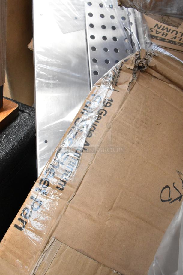 Cardboard box containing perforated metal sheets, labeled "19 Gauge Aluminum." Box shows signs of wear.