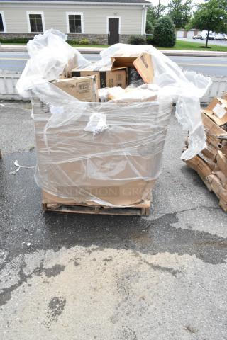 Large pallet of assorted cardboard boxes wrapped in plastic, condition appears mixed. Some boxes show wear and tear.