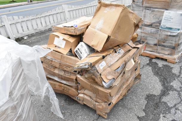 Damaged pallet of assorted cardboard boxes, some marked "Made in China," with packaging tape and labels, on asphalt.