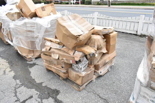 Pallet of damaged cardboard boxes, wrapped partially in plastic, showing visible wear and tear.