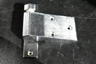 Metal hinge bracket with three screw holes, textured finish. Polished and in new condition, suitable for heavy-duty use.