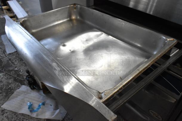 Large stainless steel tray with visible dents and wear, used condition. Suitable for industrial or commercial kitchen use.