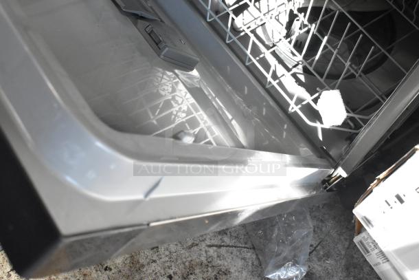 Open stainless steel dishwasher with visible racks, clean interior, and soap dispenser, in good condition.