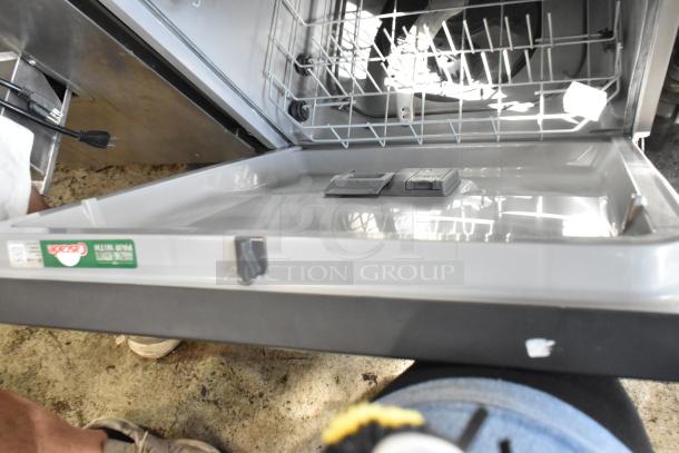 Open dishwasher with upper rack, detergent dispensers, and Tasade label. Appears in used condition.