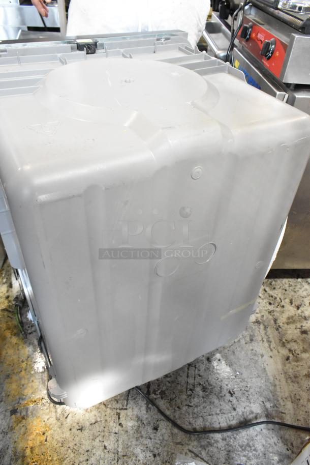 Gray industrial dishwasher, fair condition, visible wiring, robust plastic casing with minor scratches. No visible brand markings.