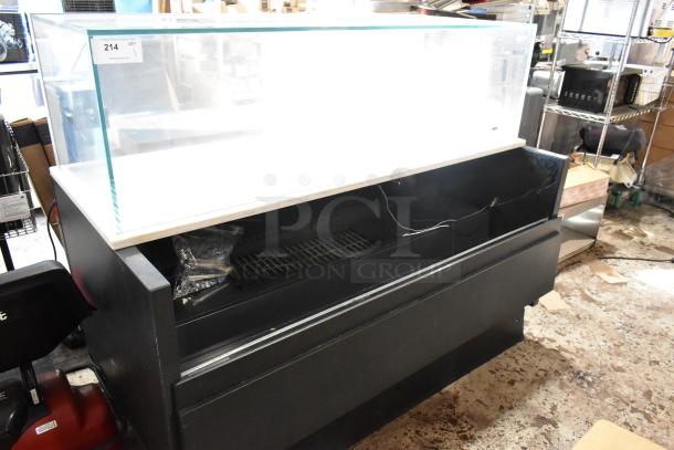 Black refrigerated display case with glass top, in used condition. Visible label reads "214 QTY." Electrical cords present.
