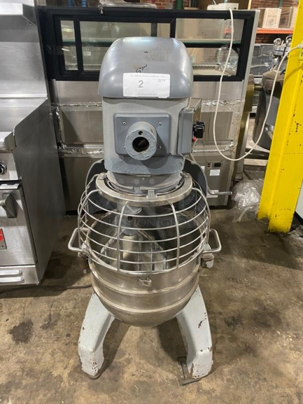 Commercial dough mixer, heavy-duty, stainless steel bowl, protective wire guard, marked with auction tag. Used condition.