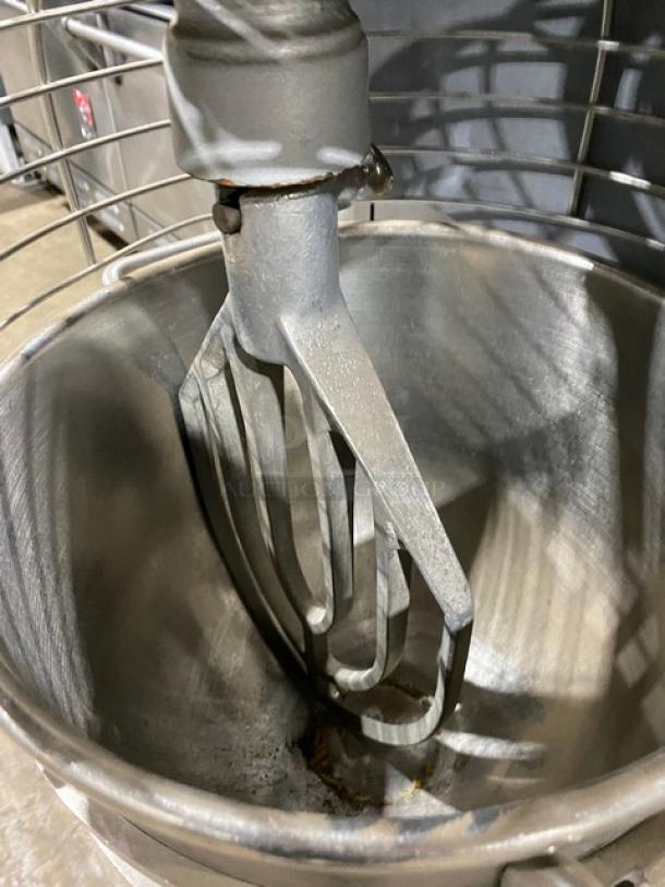 Commercial stand mixer with stainless steel bowl and paddle attachment, in good condition, ideal for bakery use.