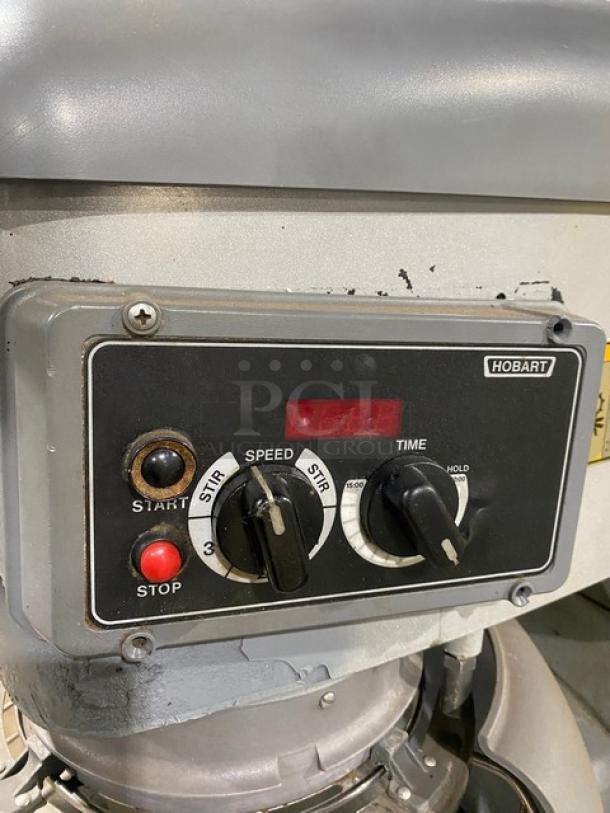 Hobart mixer control panel with speed and time dials, start/stop buttons. Marked 'Hobart', in used condition.