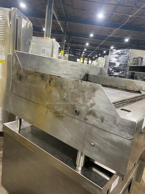 Commercial griddle with stainless steel body showing signs of wear; used condition. Ideal for high-volume cooking.