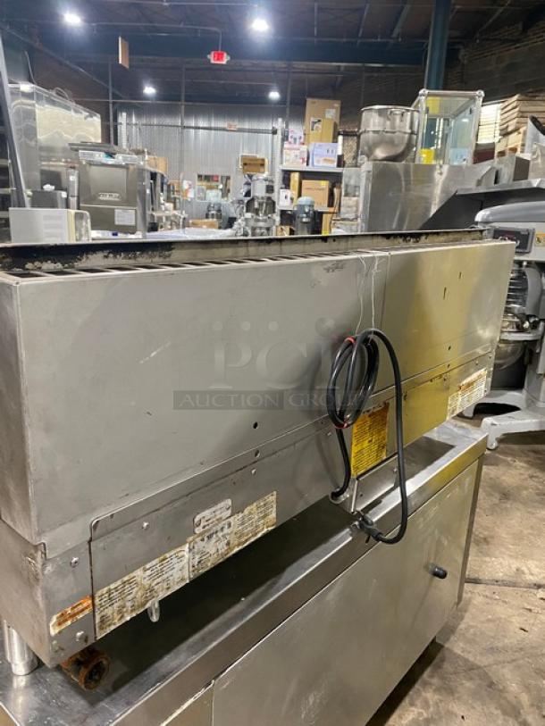 Commercial stainless steel conveyor oven, used, with visible wear. Features electrical cord and manufacturer labels.