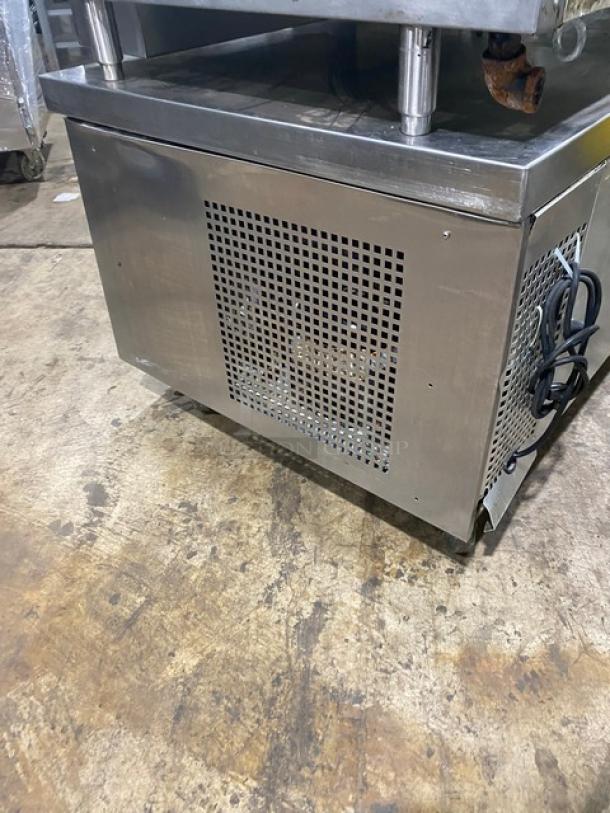 Commercial stainless steel refrigeration unit with ventilation grille, showing power cord. Used condition.