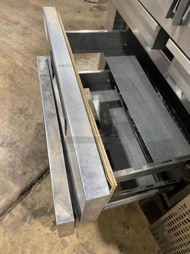Stainless steel commercial kitchen drawer unit, two open drawers. Good condition with minor wear. No visible markings.