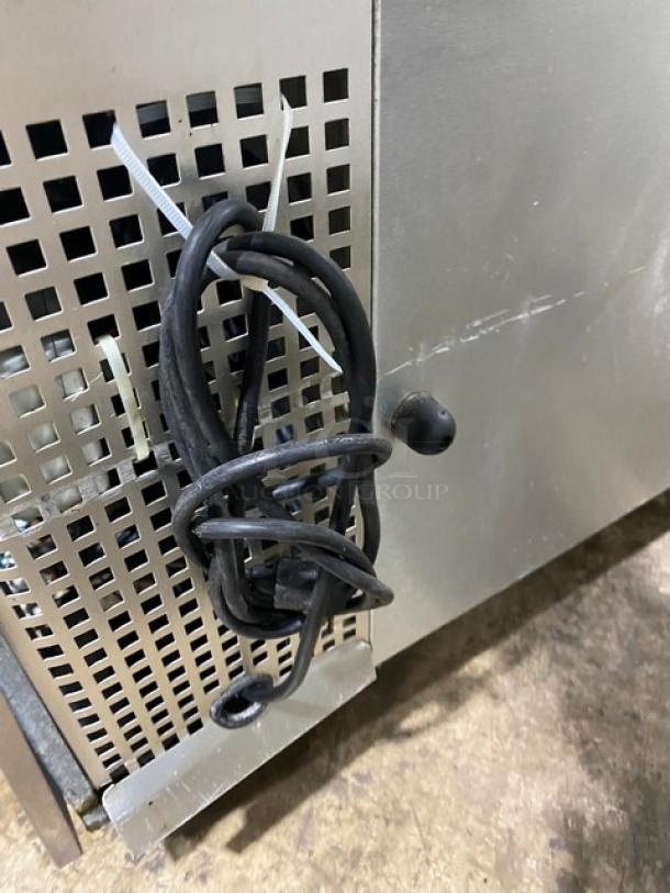 Metal appliance with vented panel, attached coiled black cord. Used condition, visible scratches and wear.