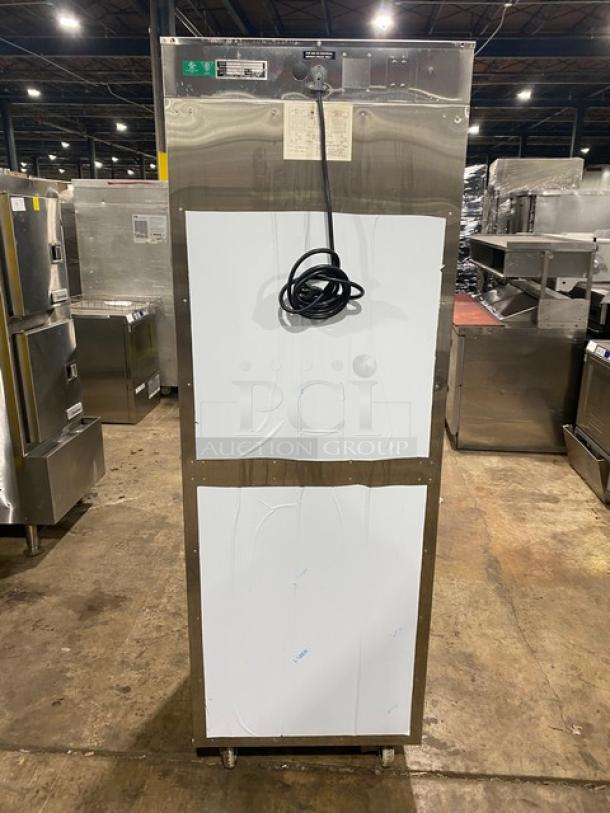 Commercial stainless steel refrigerator with dual panels and coiled power cord. Good condition. Interior shelves not visible.