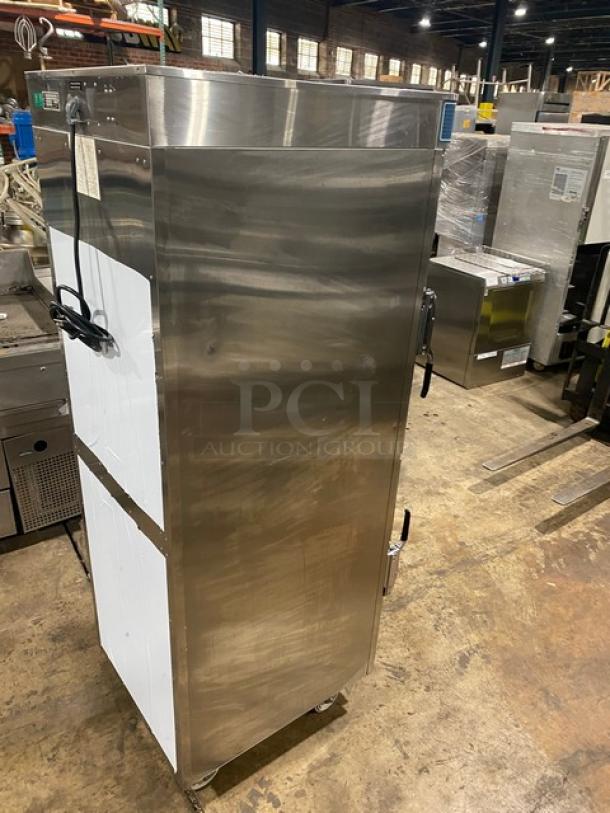 Stainless steel commercial warming cabinet on wheels, with hinged doors, handles, and visible control panel. Good condition.