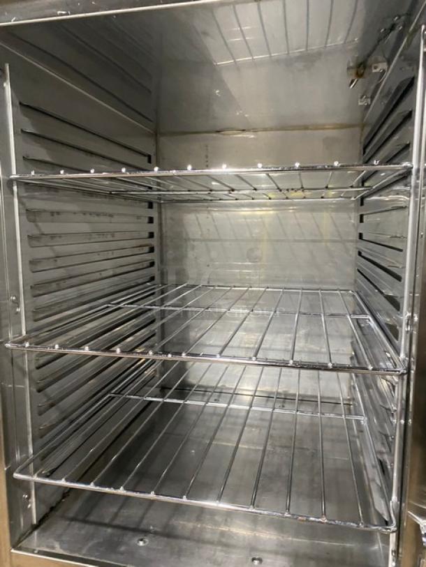 Commercial stainless steel oven interior with three wire racks; clean and spacious, suitable for heavy-duty use.