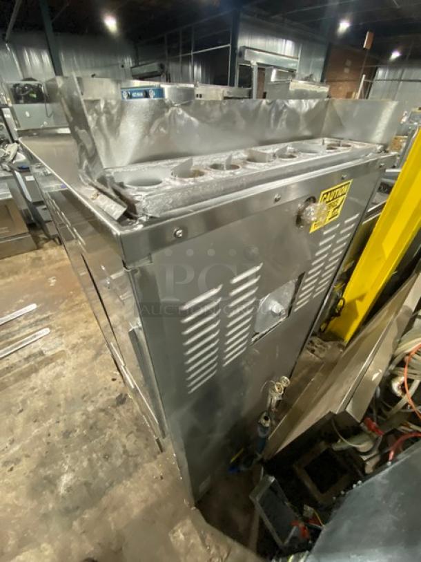 Commercial stainless steel fryer, industrial-grade, visible ventilation panels, caution label on side, used condition.