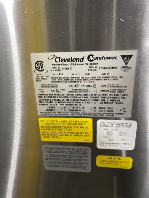 Cleveland Manitowoc industrial appliance label, model 24CGP10, 115 volts, 12.6 kW, yellow and white safety tags attached.
