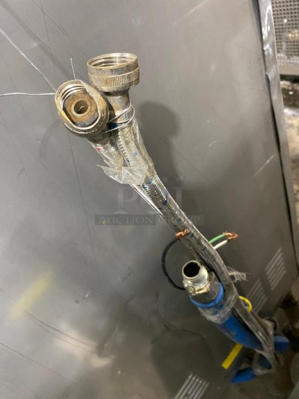 Industrial metal hoses with connectors, wrapped in tape, used, some visible wear, suitable for plumbing or machinery.