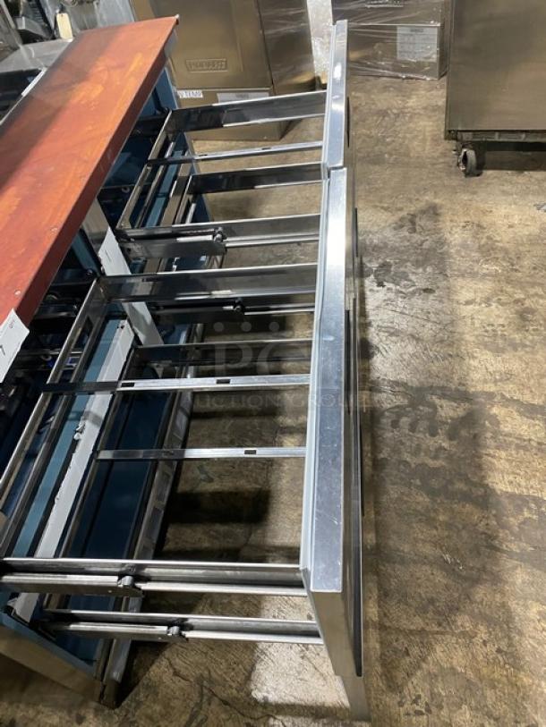 Stainless steel restaurant food service table frame, six slide rails, industrial setting, no visible tags or markings.