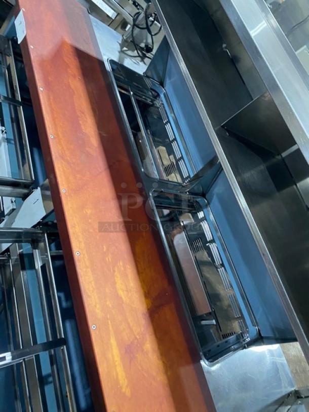 Industrial conveyor system with stainless steel and rust-colored components, showing signs of wear. Suitable for manufacturing.