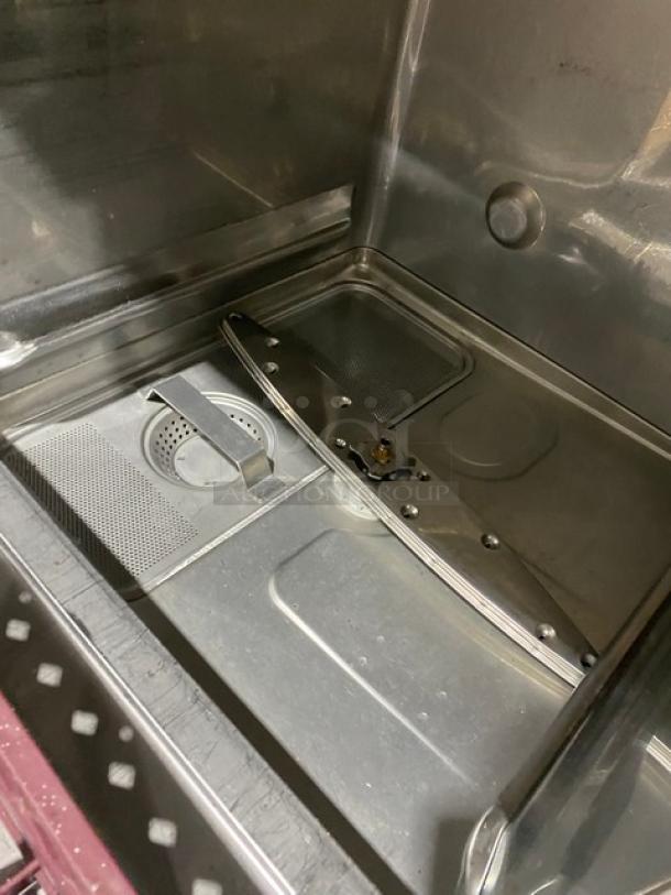 Commercial dishwasher interior, featuring stainless steel finish, filter system, and spray arm. Appears in clean condition.