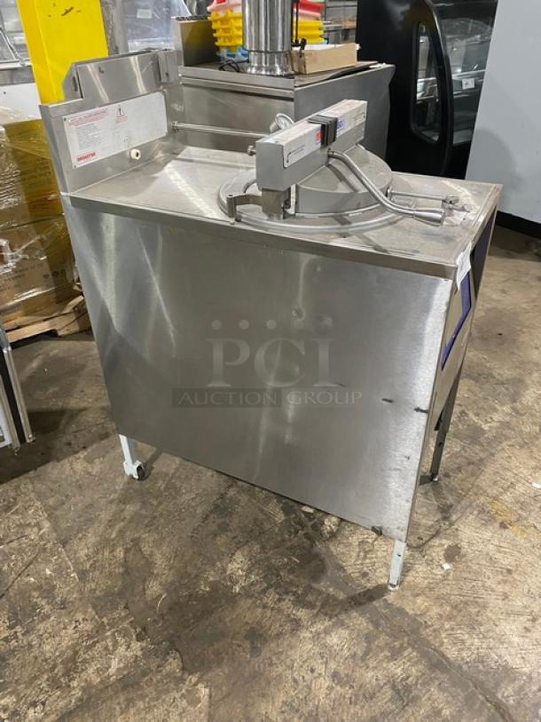 Commercial dough divider rounder machine, stainless steel body, mounted on wheels, visible labels with operation instructions, good condition.