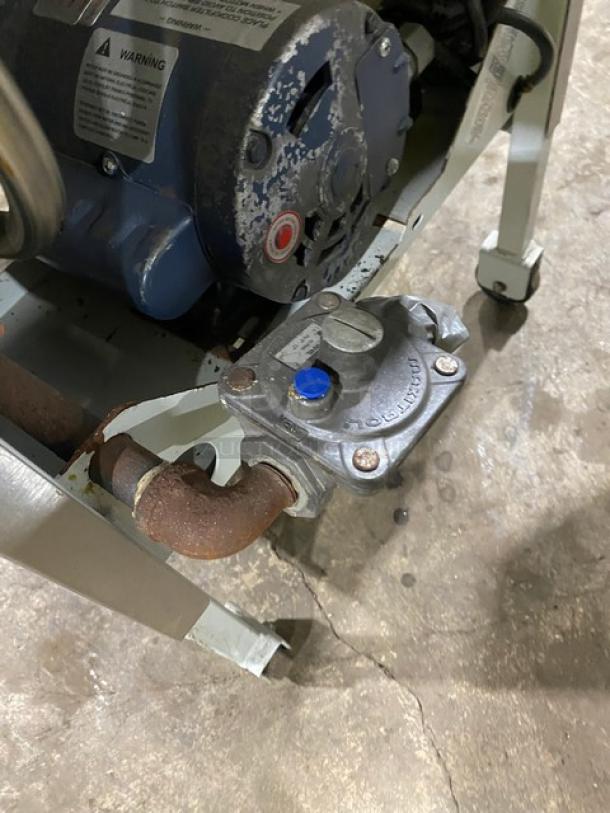 Industrial motor with attached valve, showing wear. Labels indicate safety warnings. Ideal for machinery or repair projects.
