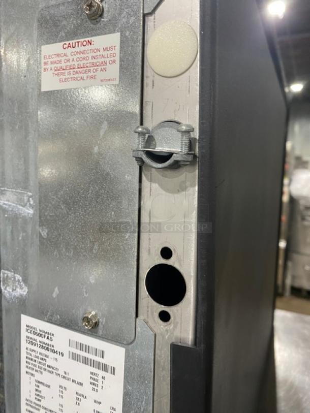 Rear view of an appliance showing model labeling and caution label for electrical connection by a qualified electrician.
