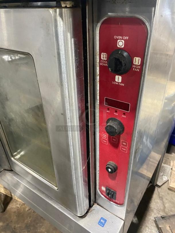Commercial convection oven with stainless steel finish, red control panel, visible wear. Features include fan controls and cool down settings.