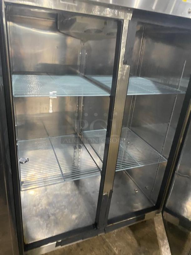 Stainless steel commercial refrigerator with glass doors, four wire shelves, excellent condition, ideal for restaurant use.