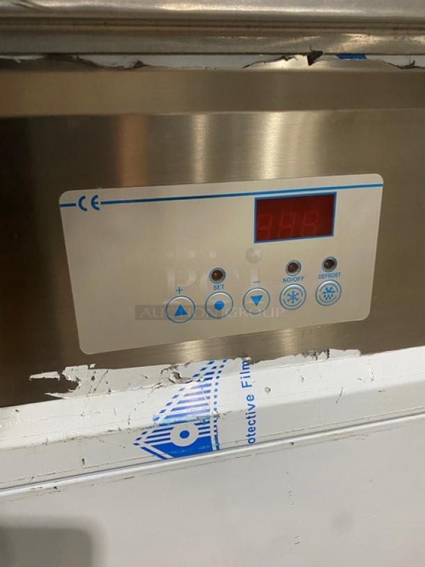 Stainless steel appliance with digital display, control buttons for settings, CE marking, visible protective film.
