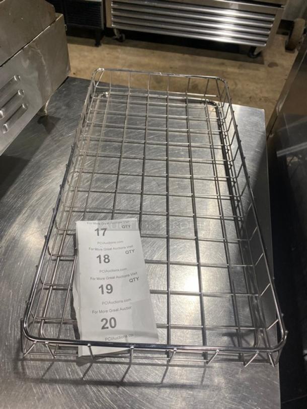 Metal wire basket tray on stainless steel surface, in good condition. Auction tags numbered 17 to 20 are visible on the tray.