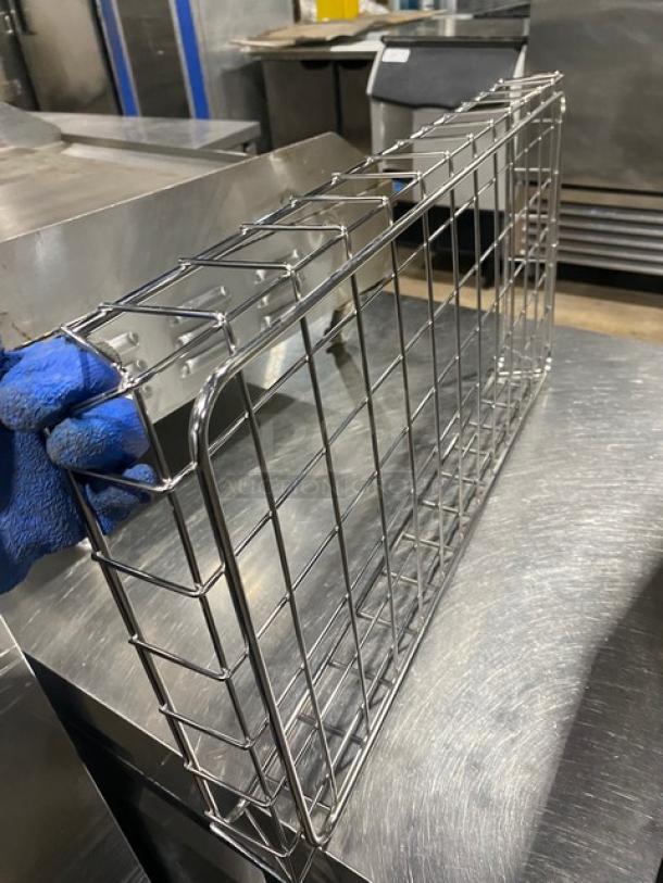 Stainless steel wire rack in excellent condition, held by blue-gloved hand. Sturdy construction, ideal for storage.
