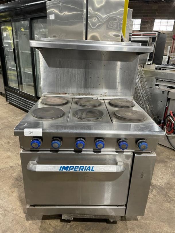 Industrial-grade Imperial electric range with six burners, oven, and shelf. Features blue knobs, stainless steel finish. Used condition.