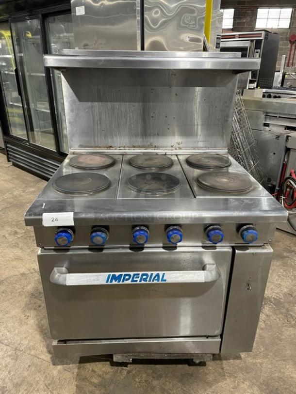 Commercial Imperial stove with six burners, blue control knobs, and front oven. Stainless steel, good condition, labeled "24."
